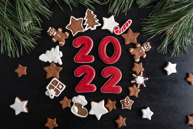 Inscription 2022 surrounded ginger biscuits glazed sugar icing. Christmas cookies stars, fir-tree and other