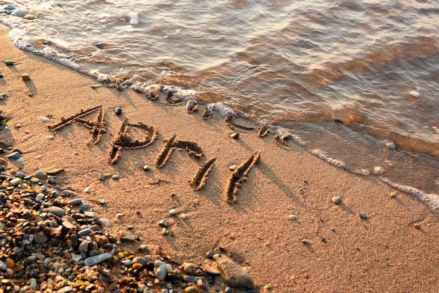 Inscription April on a beach sand