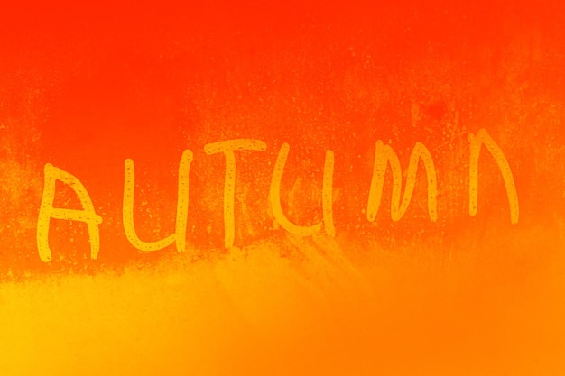 Inscription autumn on a wet glass closeup
