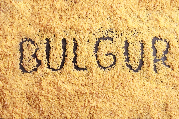 Inscription Bulgur from the grains of bulgur on a black background