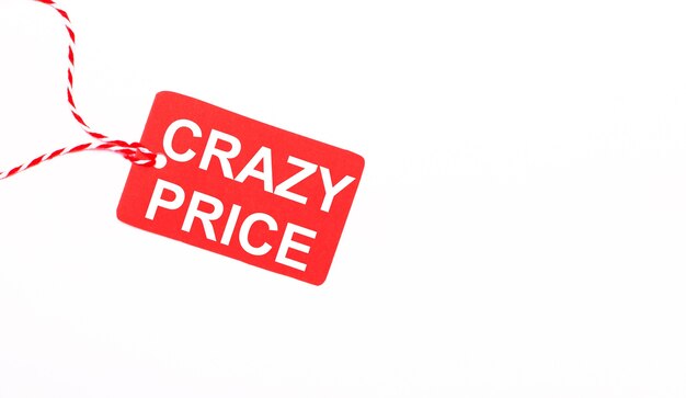 Надпись CRAZY PRICE на красном ценнике на светлом фоне. Рекламная концепция. Копировать пространство