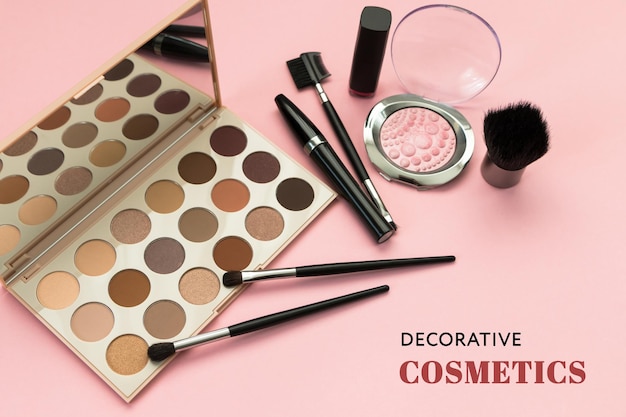 The inscription DECORATIVE COSMETICS eyeshadow palette brushes mascara on a pink background