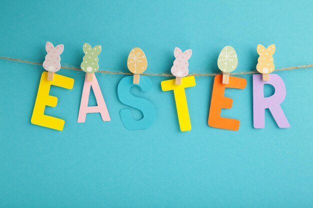 Photo inscription easter on blue background, a rope with clothespins. the concept of postcards for the easter holiday.