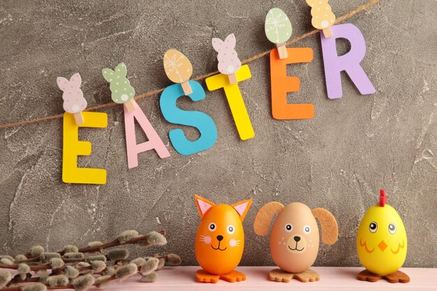 Inscription Easter on rope with clothespins and eggs on grey background The concept of postcards for the Easter holiday