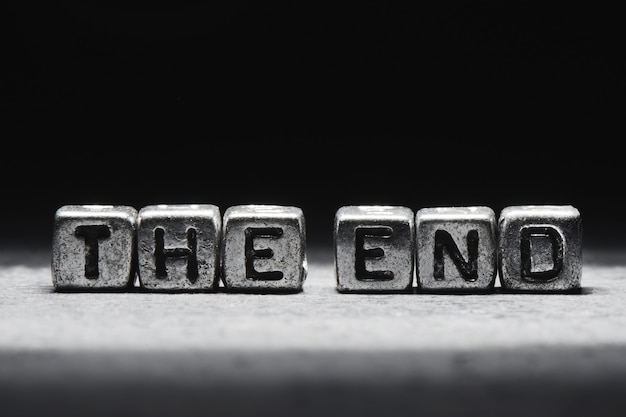 Photo inscription the end on metal cubes in grunge style on a black background isolated