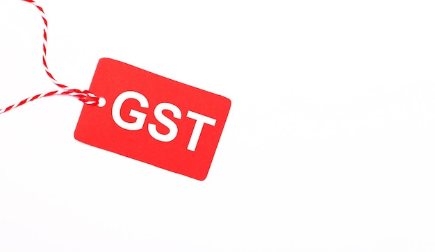 Надпись GST Goods and Services Tax на красном ценнике на светлом фоне Рекламная концепция Copy space