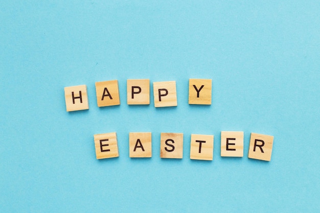 Inscription happy easter on blue background with copy space