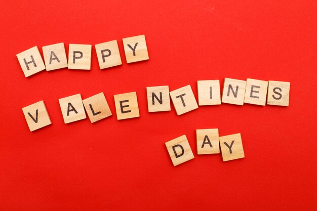 Надпись с Днем святого Валентина с сердечками на красном фоне