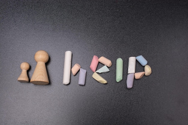 Photo the inscription on the help of colored chalk beside people figurines