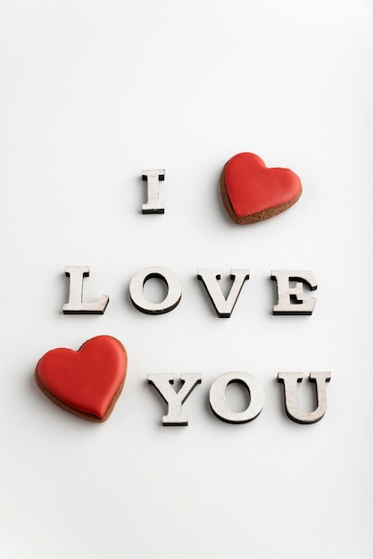 Inscription I LOVE YOU and red heart shaped gingerbread white background Valentines day Vertical frame