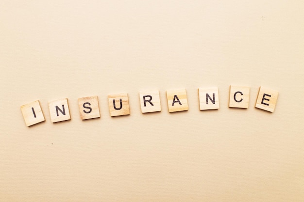 Inscription insurance on a green background made by wooden blocks.