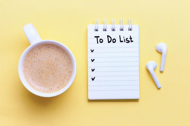 Photo inscription do list in notebook and cup of coffee on a yellow background