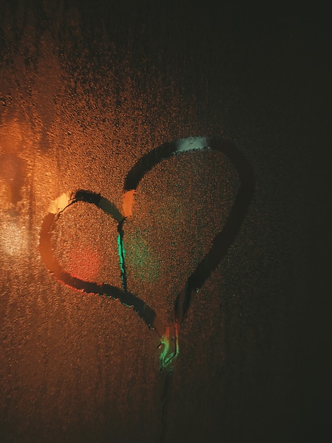 The inscription love on the fogged glass. Neon lighting. Love sign on glass