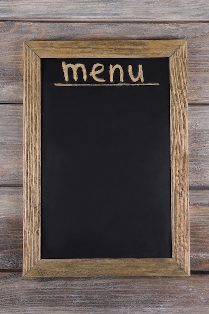 Inscription menu on chalkboard on table closeup