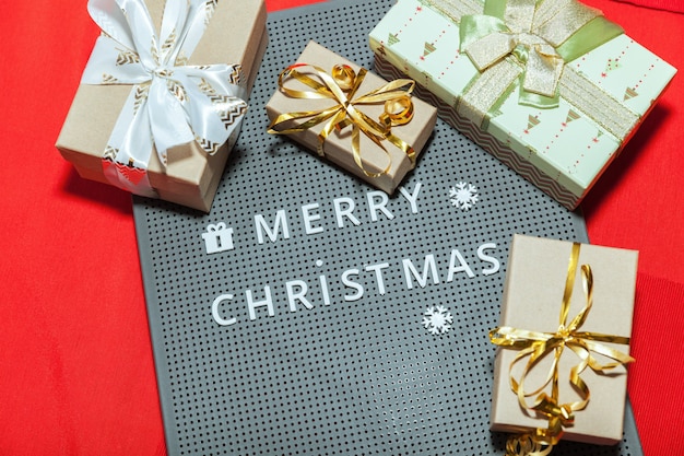 赤い背景にギフトとメリークリスマスの碑文
