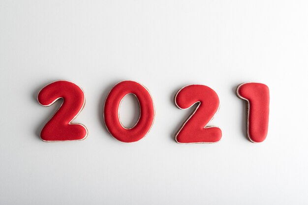 Inscription in red numbers 2021 from gingerbread on white background. Happy New Year 2021