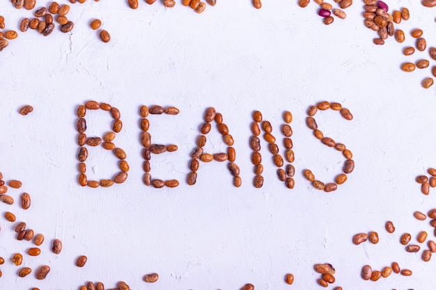 The inscription of red spotted raw bean protein for vegetarians on a white textured background