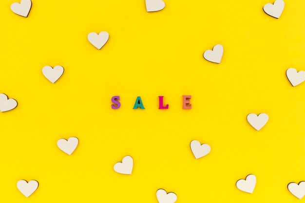 Inscription sale in wooden letters on a yellow background