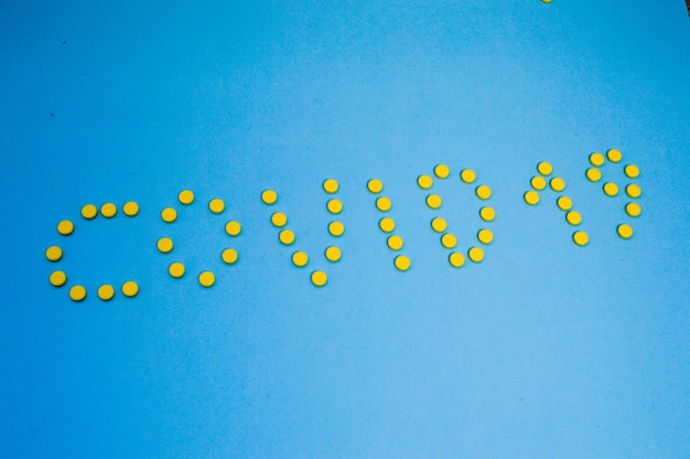 The inscription sovid 19 made of round yellow medical pharmaceutical tablets from coronavirus