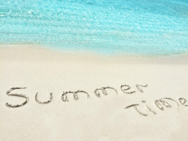 Photo inscription summer time in the sand on a tropical island maldives