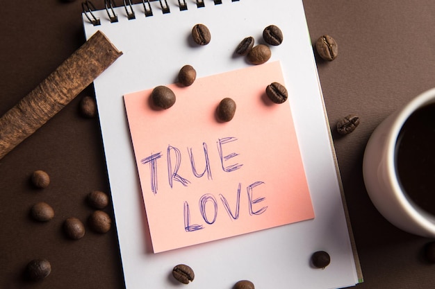 The inscription true love and a notepad with a cup of coffee