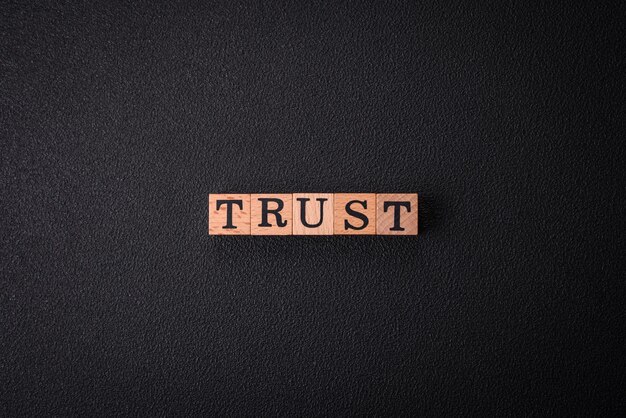 Photo the inscription trust made of wooden cubes on a plain background