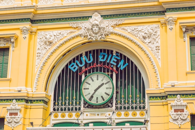 The inscription on the Vietnamese post office Saigon Central Post Office on blue sky background in Ho Chi Minh, Vietnam. Steel structure of the gothic building was designed by Gustave Eiffel.