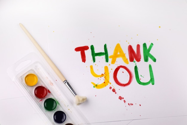 Inscription on a white sheet of paper with watercolors "Thank you"