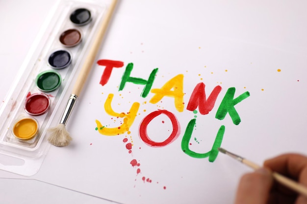 Inscription on a white sheet of paper with watercolors "Thank you"