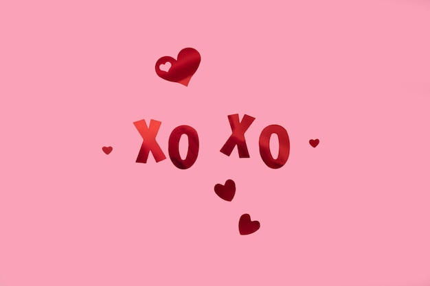 The inscription xo xo glitter and hearts on a pink background