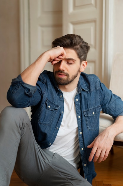 Photo insecure man sitting on floor front view