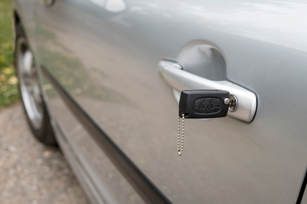 Inserted key in the car door outdoors. Close up of a carbody with the key left in the lock. Unlocking the vehicle doors. Opening motor before moving. Remote control car key set in the lock.