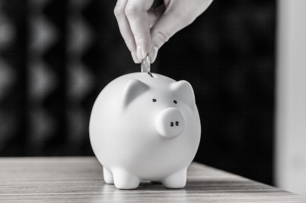 Inserting a coin into a piggy bank