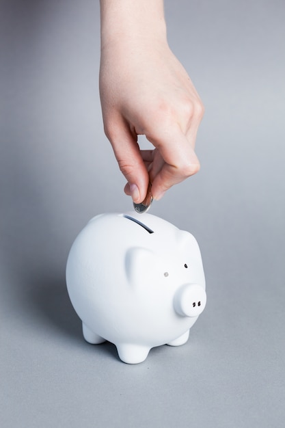 Inserting a coin into a piggy bank