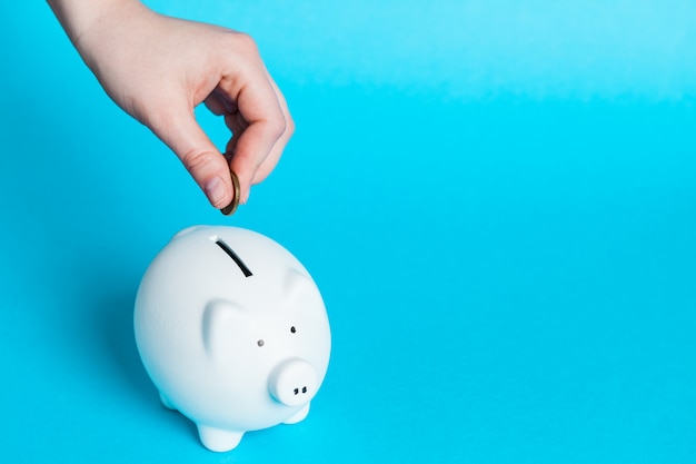 Inserting a coin into a piggy bank