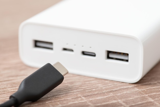 写真 白い電源バンクに usb タイプ c ケーブルを挿入する