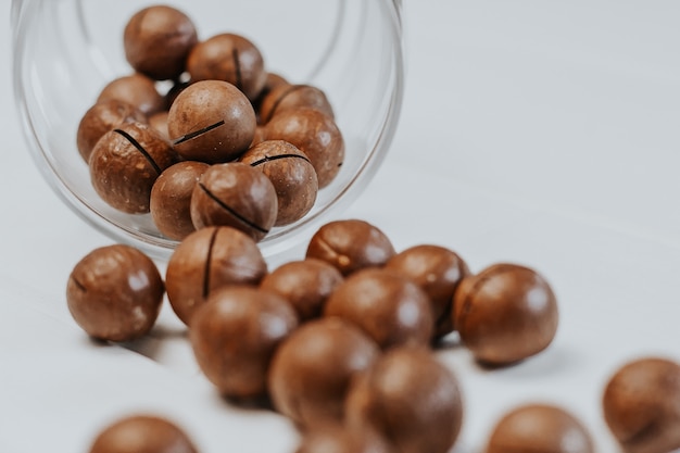 inshell macadamia nuts on light gray. macadamia in a glass jar 