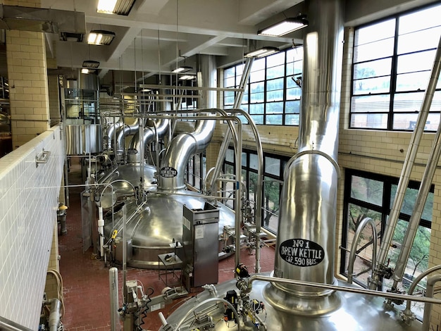 Photo inside of a beer factory with metallic brew kettle stations