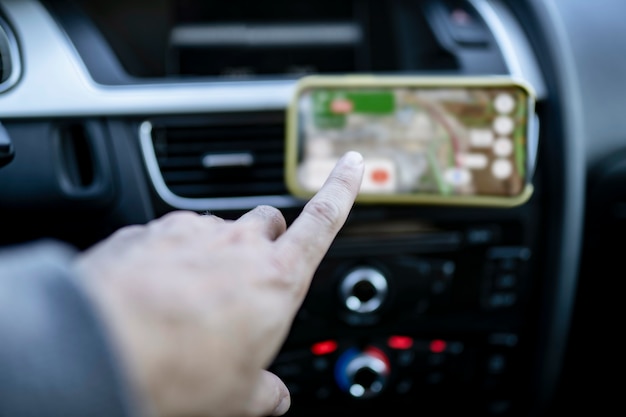 Photo the inside of a car, hand using navigation