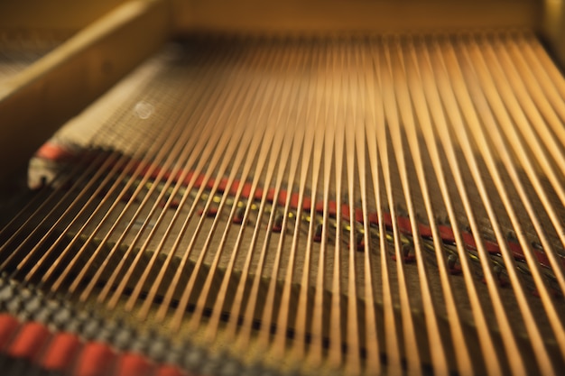 The inside of a classical  grand piano instrument with copper cord strings.
