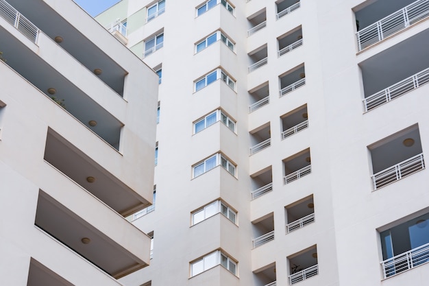 Inside corner of a multi-story residential building, close view of windows and balconies.