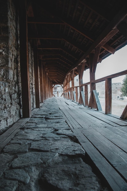 The inside of a covered walkway is a long wooden walkway.