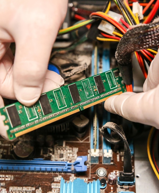 Inside details of the old personal computer Cooler motherboard wires and video card in the dust Man is holding cables in his hand Broken PC