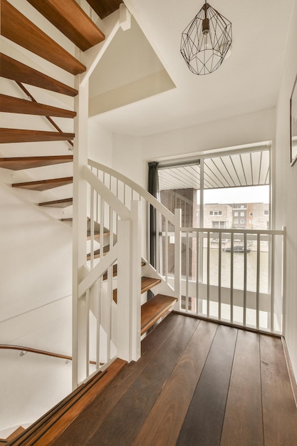 Foto l'interno di una casa con pavimenti in legno e ringhiere bianche su entrambi i lati della scala che porta al secondo piano