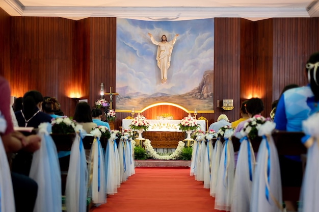 Inside large Christian church picture of Jesus on the wall and many people were attending religious ceremonies a Sacred Christian Ceremony Holy Communion Divine Mass Guidance of the Bible