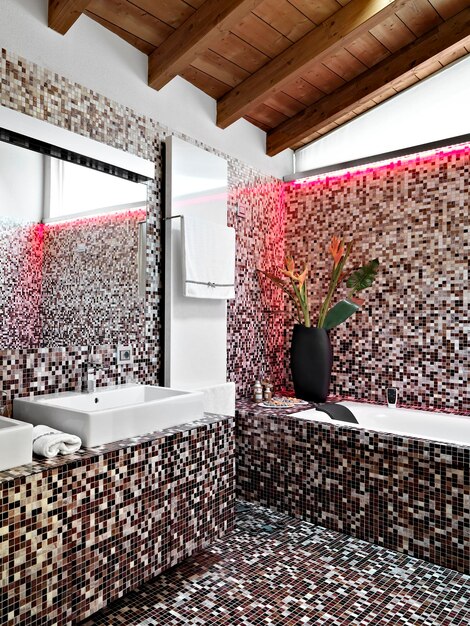Foto all'interno di un bagno moderno in mansarda a sinistra un lavabo da appoggio sullo sfondo c'è