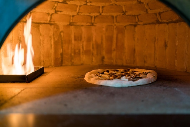 나폴리 피자를 굽기 위한 오븐 내부 고온의 가스불 클래식 이탈리안 피자 오븐 크러스트가 빠르게 부풀어 오르고 토핑이 살짝 까맣게 타서 바삭바삭 전통 방식으로 구워짐