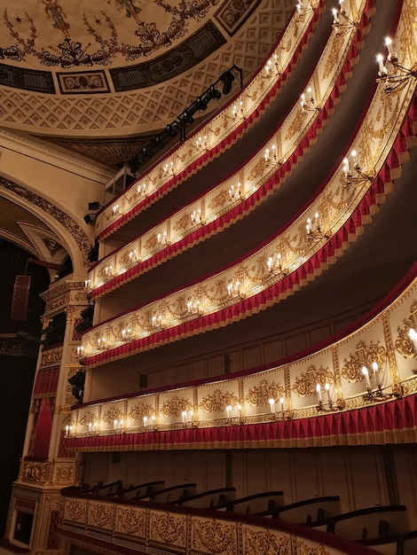 Inside view of royal box of alexandria theater red golden details rows performance chandelier rows