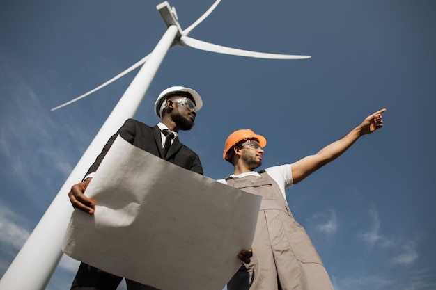 Foto inspecteur en ingenieur praten op veld met windturbines