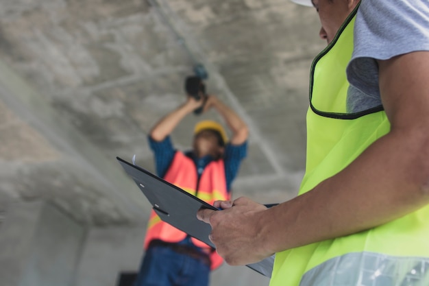 Inspector checking worker working in construction site